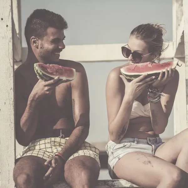 First date on the beach eating watermelon