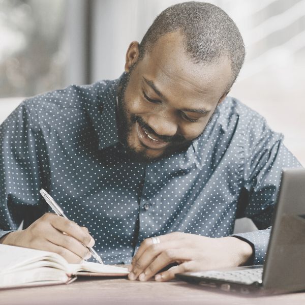 Man writing positive affirmations