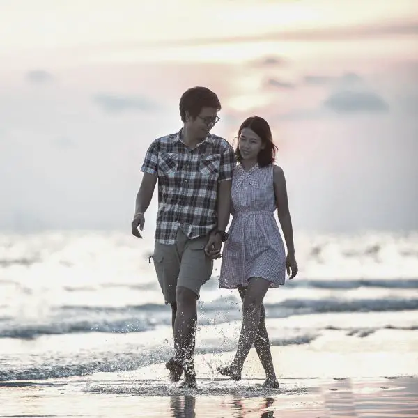 boyfriend and girlfriend walking on the beach