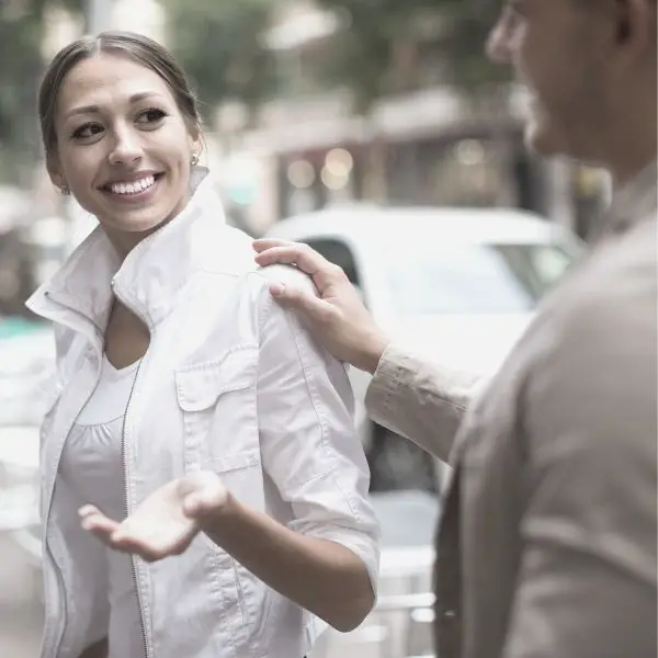 man touching smiling woman on sholder
