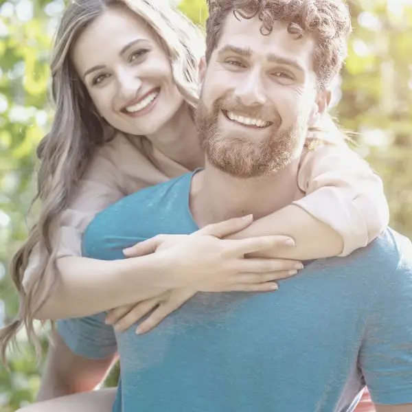 Girlfriend riding on her boyfriends back smiling