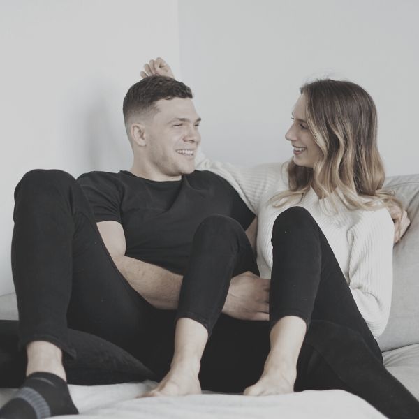 man and woman sitting on sofa enjoying each others company