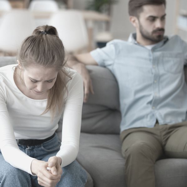 Couple sitting on couch upset