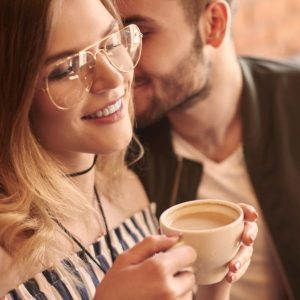 Guy flirting with a girl he is wooing in a coffee shop