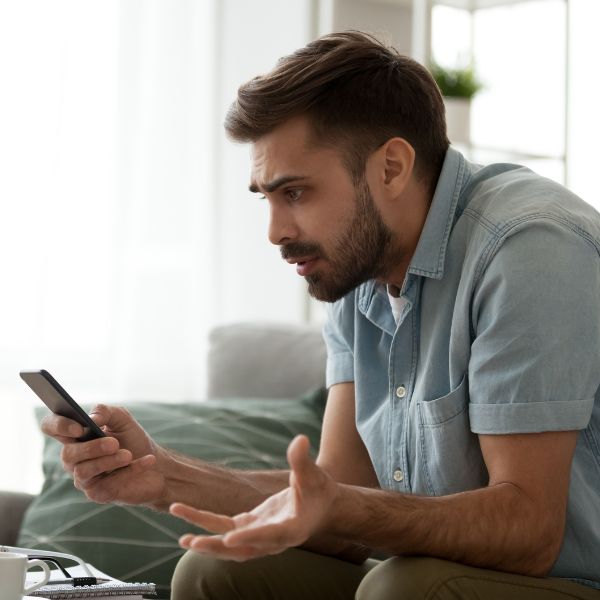 Guy looking at phone confused becasue he got ghosted by girl