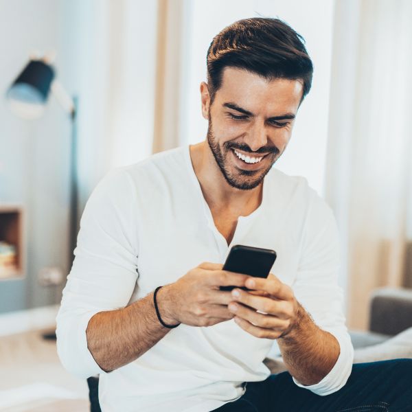 Guy smiling because he received a response from a girl over text