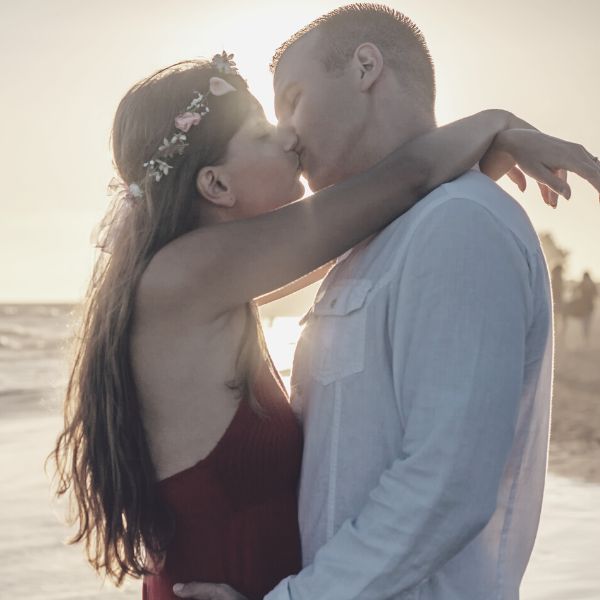 Woman kissing a man on the beach