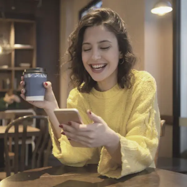 girl drinking coffee and laughing at a text from a guy she just met