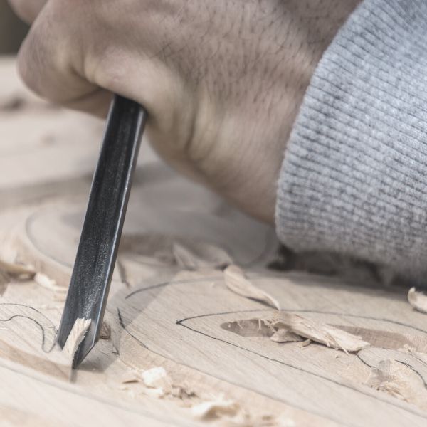 man carving wood