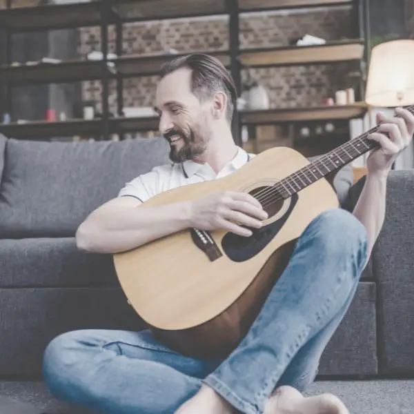 man learning to play guitar