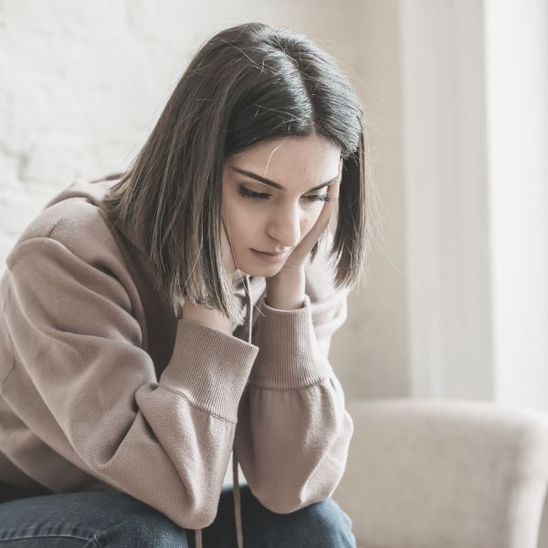 woman sitting on the couch sad