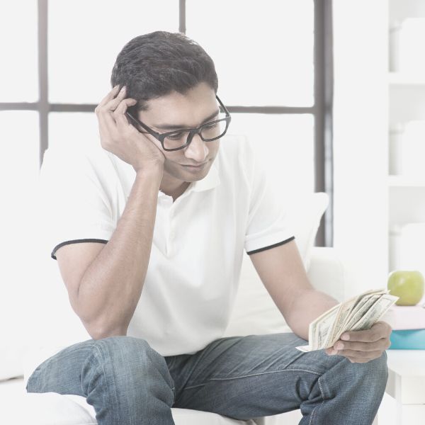 Beta male sad looking at a small amount of money in his hand