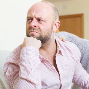 Guy sitting on couch angry feeling a lot of self hate