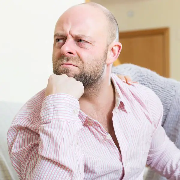 Guy sitting on couch angry feeling a lot of self hate