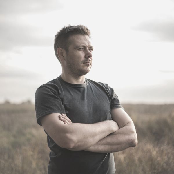 Guy standing in a feild reflecting on his life