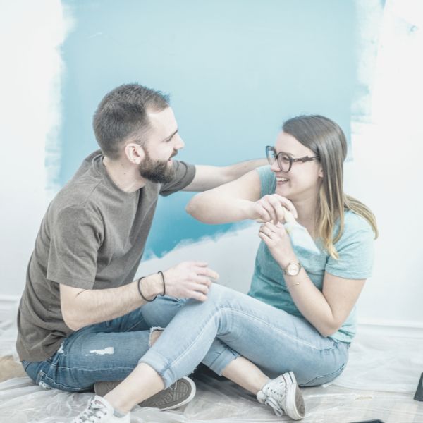 Boyfriend and girlfriend having fn painting a room together