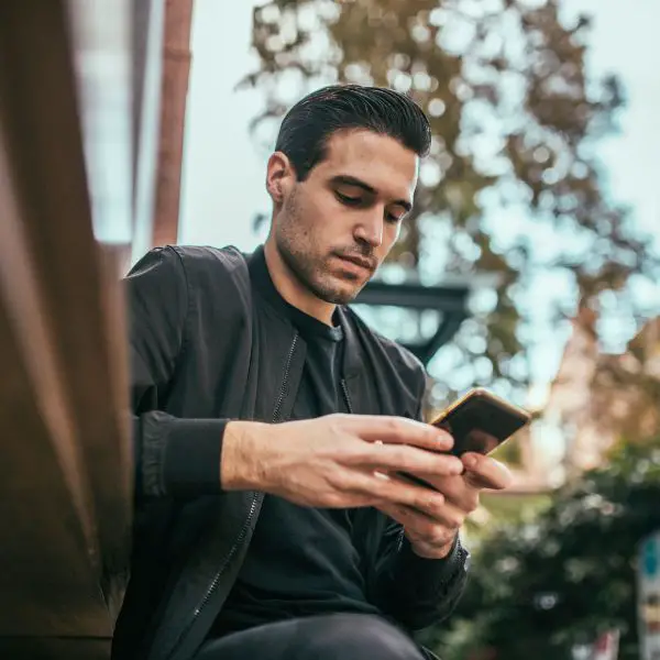 Guy looking at his phone again since a girl keeps ignoring his texts