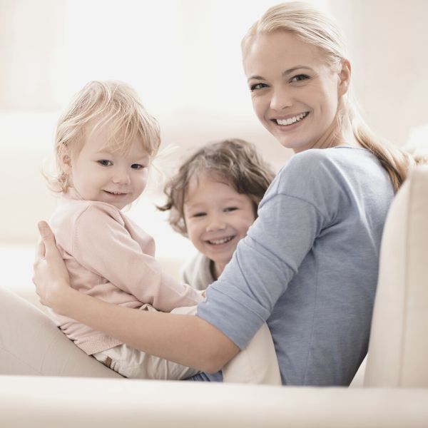 mother playing with kids on the sofa